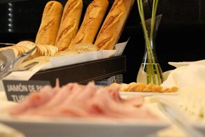 A display of bread and ham in a restaurant setting. - Open Hotel (Quillota)