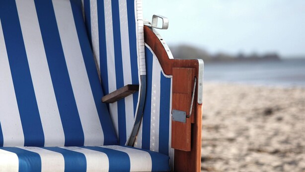 A beach chair with a striped pattern, a metal armrest, and a wooden backrest. - Vacation home Friedrichstraße 16 (Laboe)