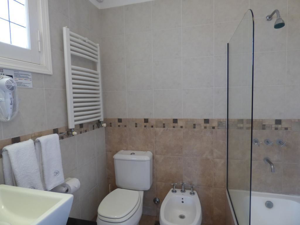 A bathroom with a toilet, bidet, sink, and bathtub.