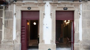 A building entrance with two doors marked 171 and 173, a checkered floor, and a visible 'AL' sign. - Guimarães IN (Guimarães)