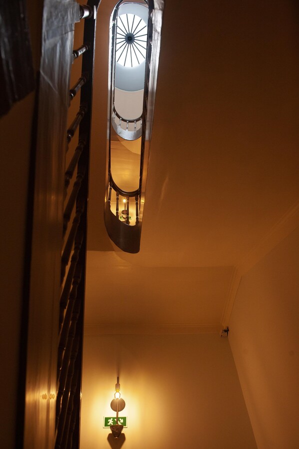 Una escalera con barandilla y un aplique con diseño circular.