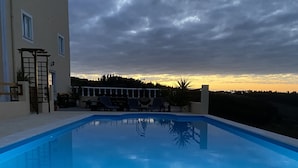 Une piscine avec vue sur une maison et des arbres en arrière-plan.