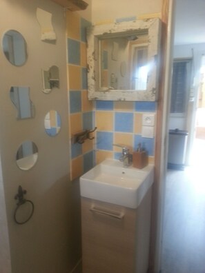 A bathroom with a sink, mirror, and tiled walls.