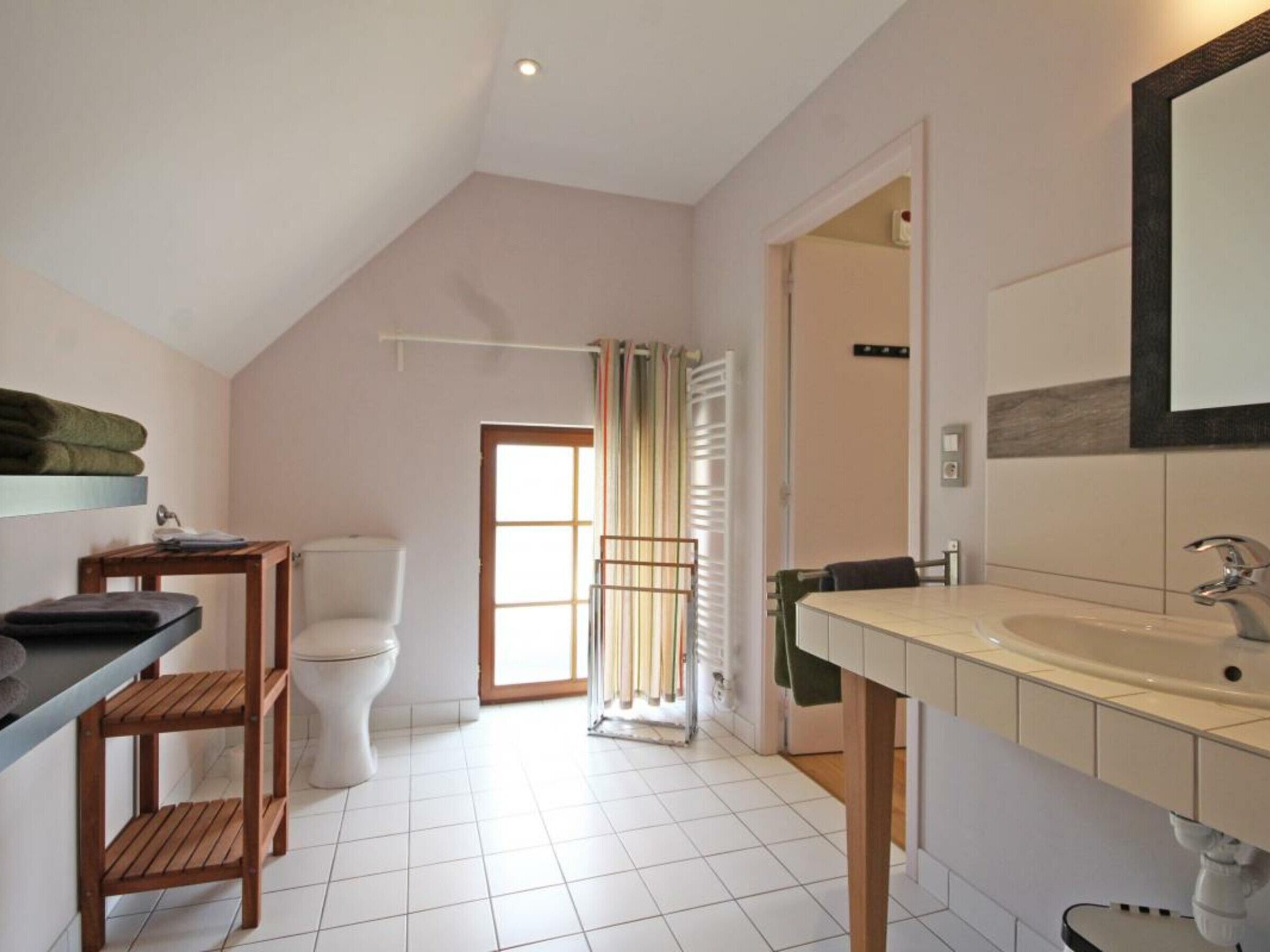 Ein Badezimmer mit Toilette, Waschbecken und Duschbereich.