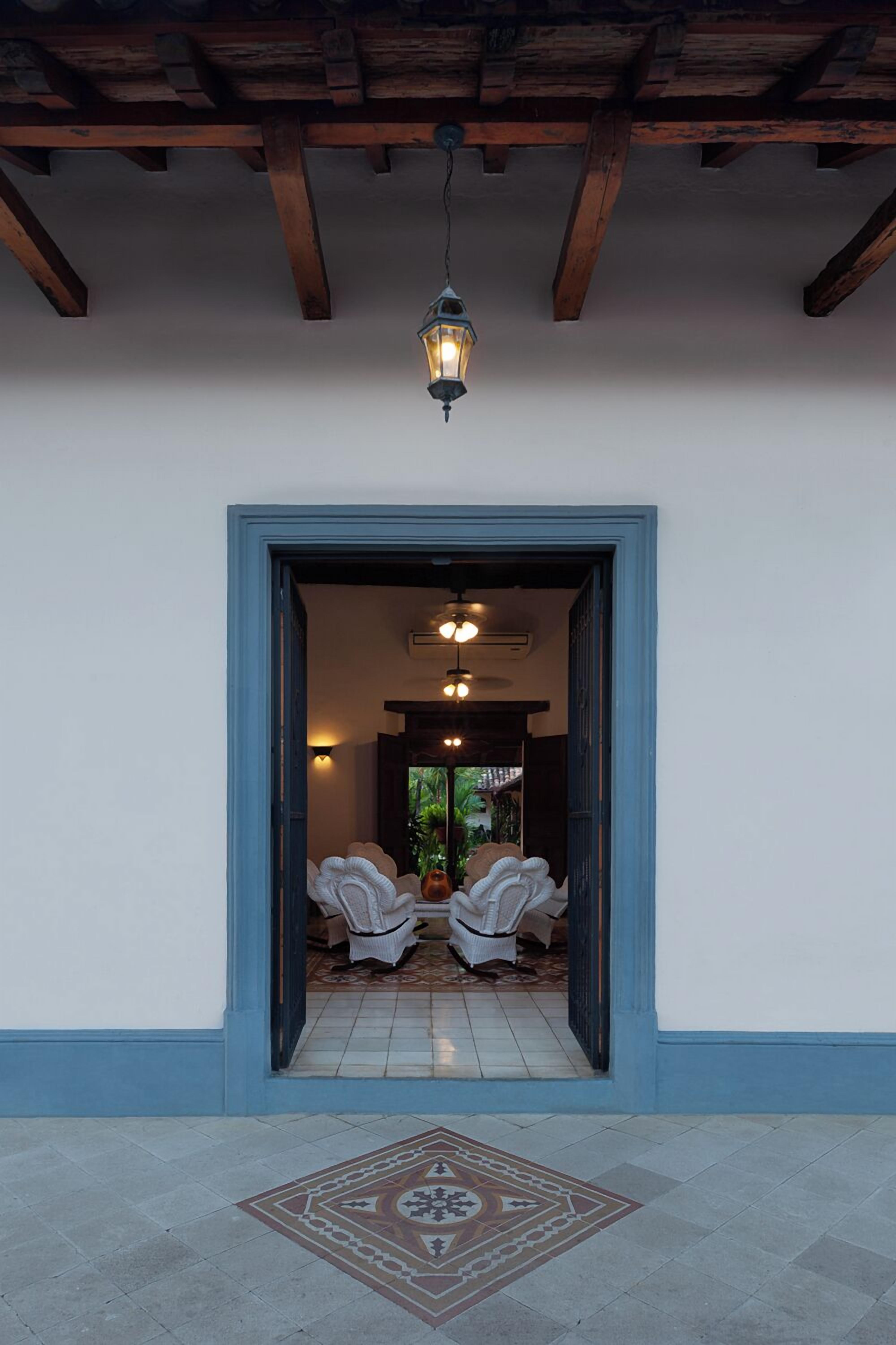 A doorway leading to a room with a tiled floor and a patterned mat.