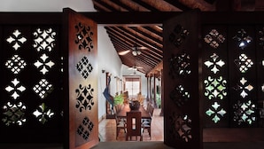 An interior space with a wooden dining area, a ceiling fan, and a view into a dining room.