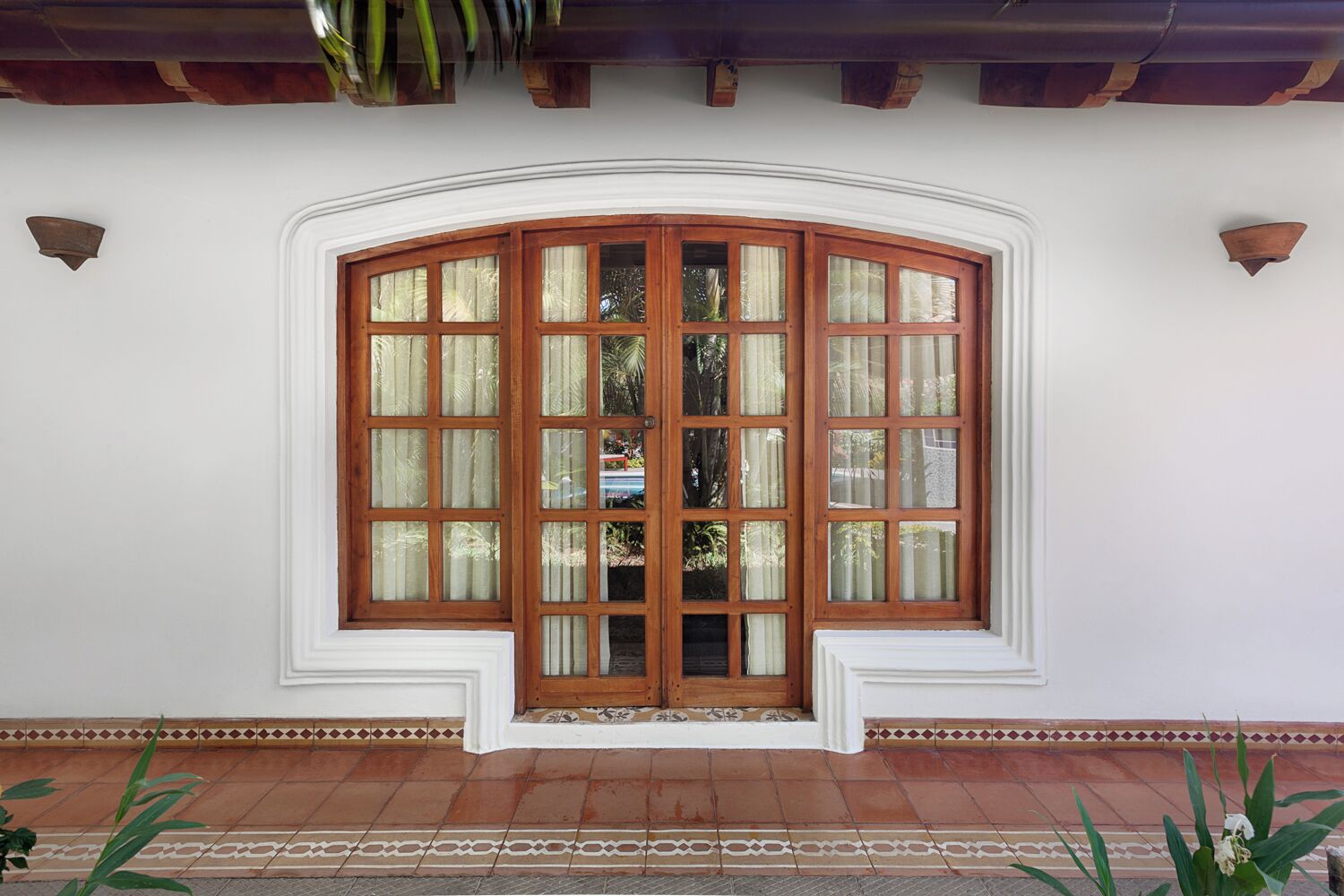A large bay window with multiple panes, a white exterior wall, and a tiled floor.