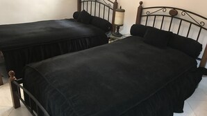 Two single beds with black bedding, a wooden headboard, and a bedside table with a lamp. - Luxury apartment in the heart of Casablanca (Casablanca)