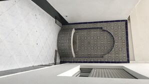 A modern interior with a geometric patterned wall, a large circular design, and a minimalist design with a sloped ceiling. - Luxury apartment in the heart of Casablanca (Casablanca)
