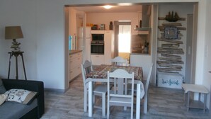 A compact living space with a dining area, kitchenette, and a small seating area.