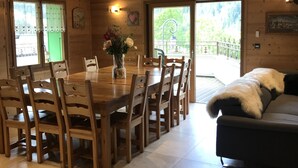Ein Essbereich aus Holz mit Tisch und Stühlen, einer Vase mit Blumen und herzförmigen Verzierungen an der Decke.