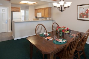 Enjoy meals in this cozy dining area with a table for four, surrounded by comfortable seating and a beautiful centerpiece.