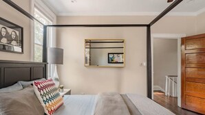 Ein modernes Schlafzimmer mit einem großen Bett, einem Spiegel und einem Holzschrank.