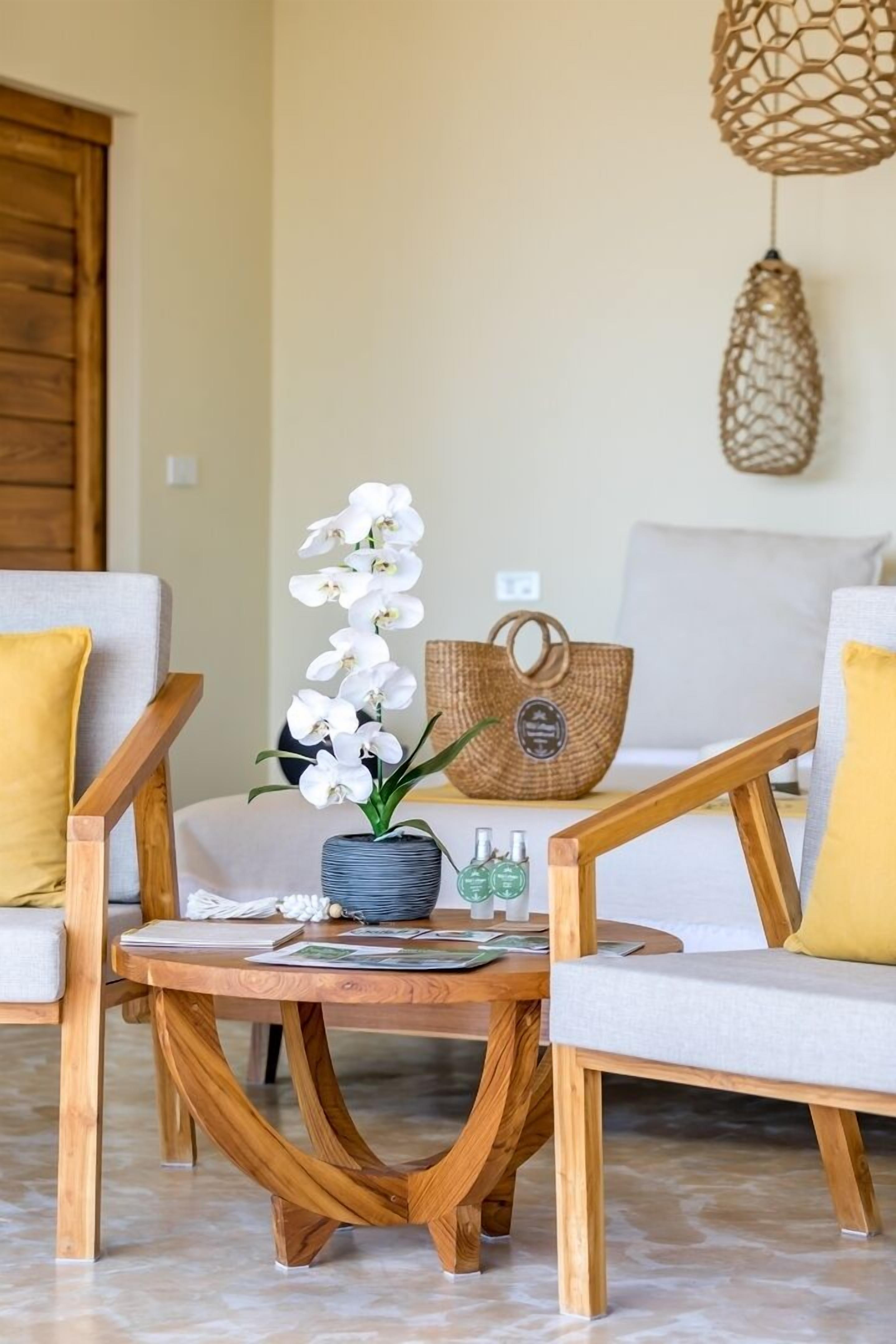 A cozy seating area with a wooden coffee table, a wicker basket, and a vase with white flowers.