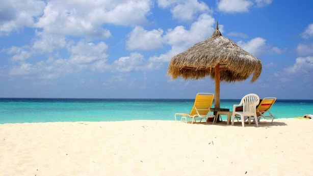 A beach with a thatched umbrella and two lounge chairs. - Aruba Eagle Beach One Happy Island Vacation Waiting For You!! (Oranjestad-West)