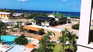 A resort with a pool, a beach view, and a building with a green roof. - Aruba Eagle Beach One Happy Island Vacation Waiting For You!! (Oranjestad-West)
