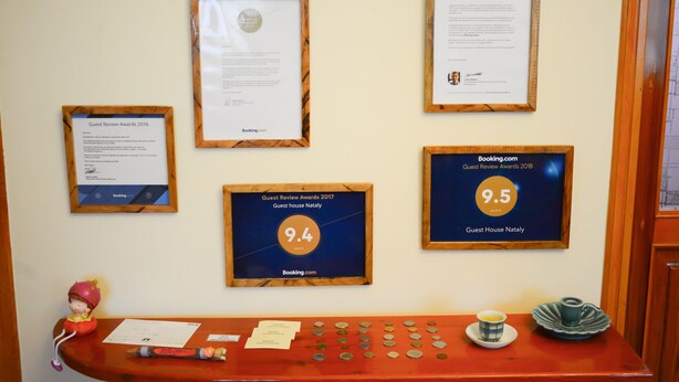 Premios de Reseñas de Huéspedes enmarcados de 2016 a 2018, una mesa de madera con varios objetos y una figura decorativa.