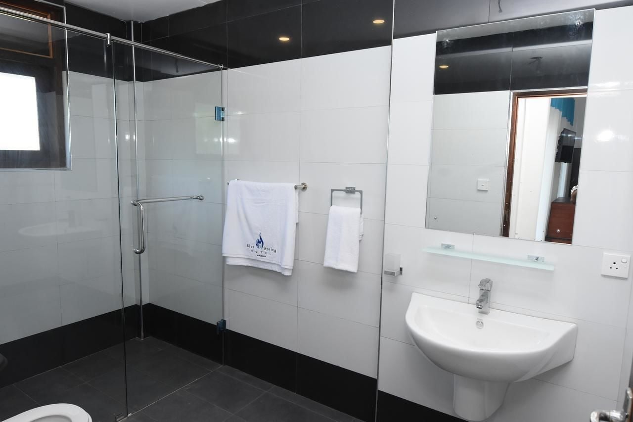 Un baño moderno con cabina de ducha de vidrio, un lavabo blanco y un espejo encima.