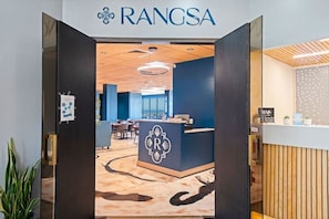 A reception area with a sign reading 'RANGSA,' a reception desk, and a modern interior design.