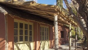 A building with a covered porch, a series of windows, and a pathway leading to the entrance.