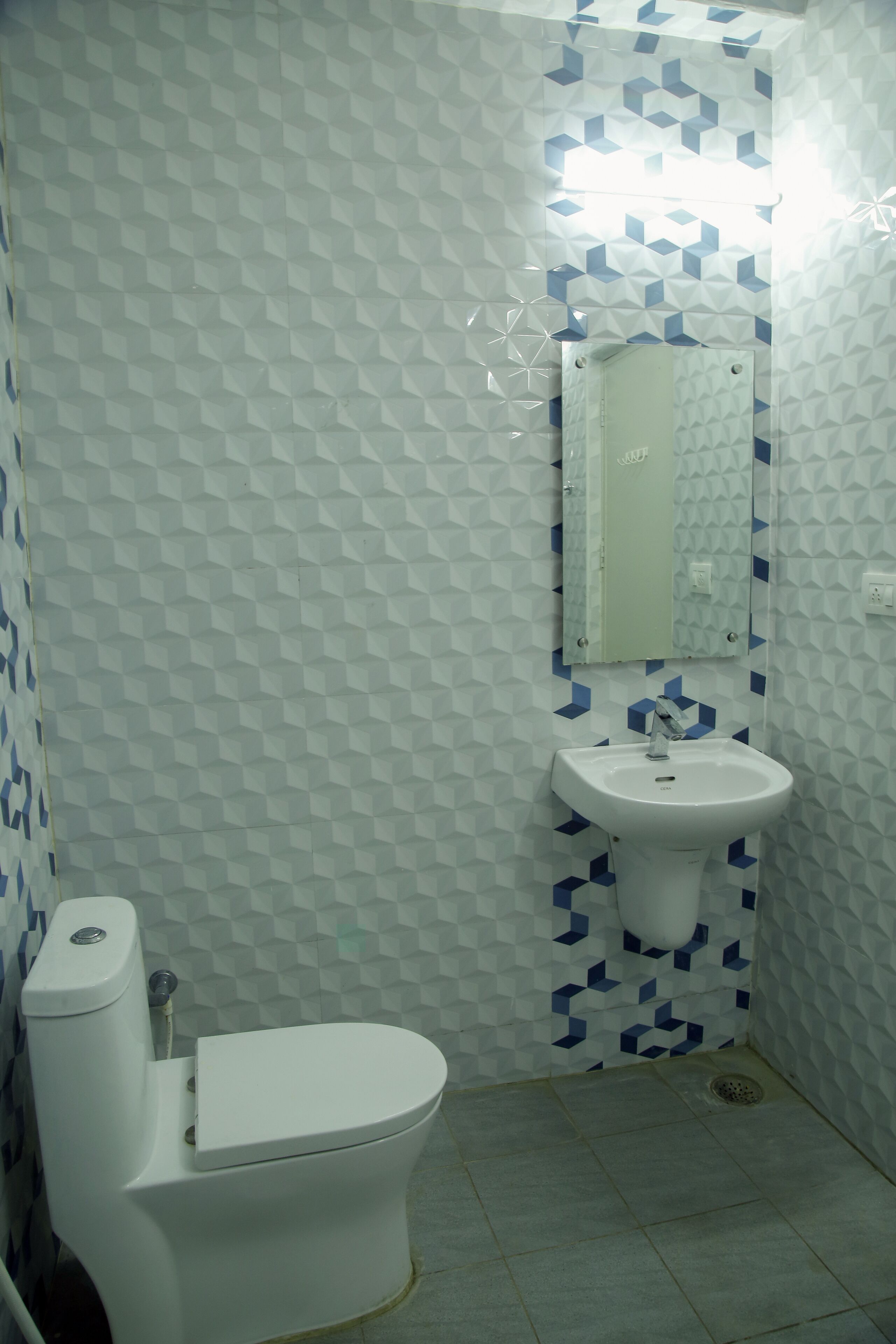A bathroom with a toilet, sink, and mirror.