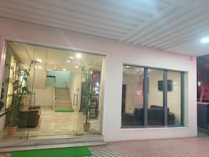 A hotel lobby with a staircase, seating area, and potted plants.