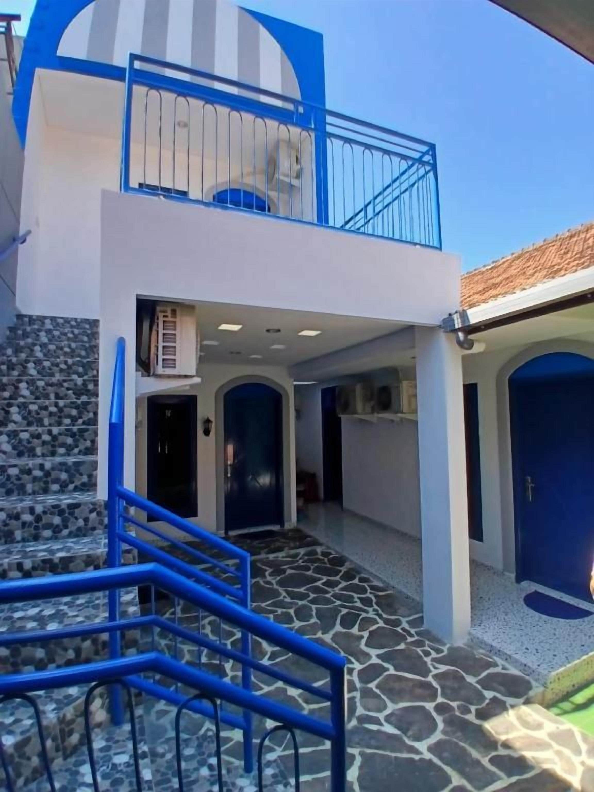 A building with a staircase, a balcony, and a door.