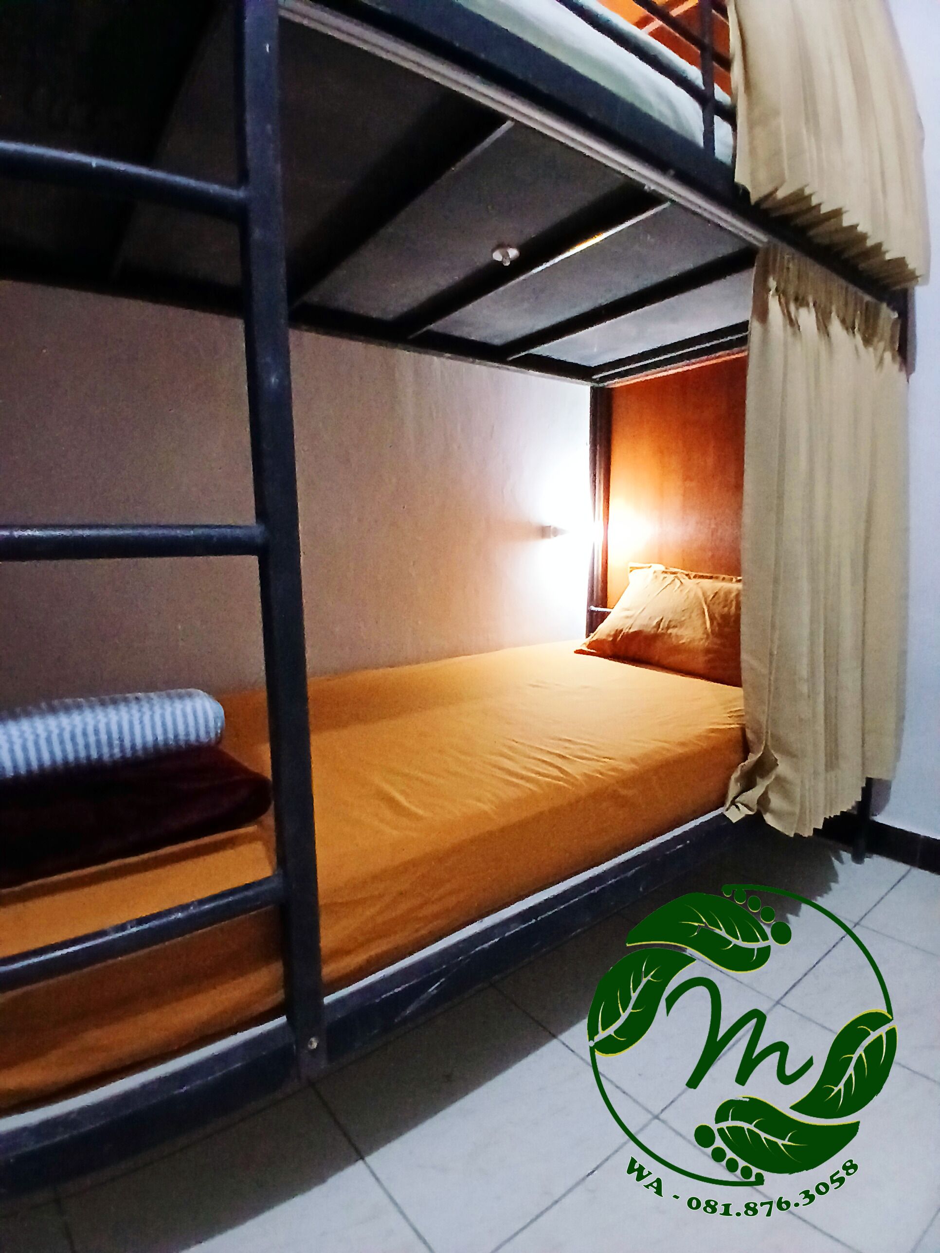 A bunk bed room with a single bed and a mattress on the lower bunk.