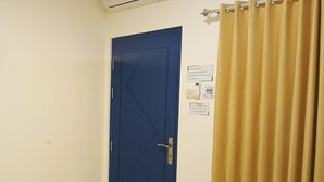 A blue door with a metal handle, a yellow curtain, and a wall-mounted sign with text. - Moshi-Moshi - Hostel (Probolinggo)