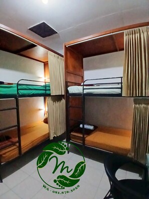 Cozy dormitory room with two comfortable beds, a chair, and a window with curtains.