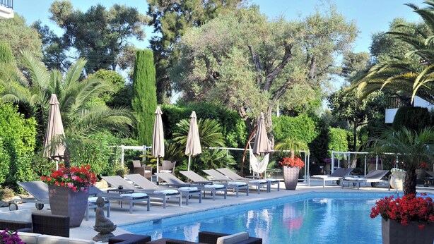 A poolside area with lounge chairs, umbrellas, and potted plants. - La villa (Antibes)