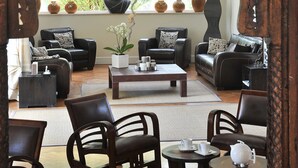 A cozy lounge area with leather sofas, a coffee table, and a decorative Buddha statue. - La villa (Antibes)