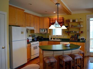 Enjoy cooking in this kitchen with a central island, microwave, and stove.