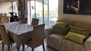 A dining area with a table and chairs, a sofa with cushions, and a large painting on the wall. - Supersized whole floor Residence Near Manly (Balgowlah)