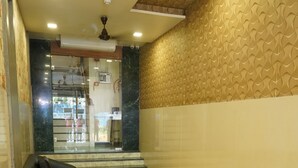 A reception area with a reception desk, a waiting area with a sofa, and a patterned wall. - Sharda residency (Mumbai)