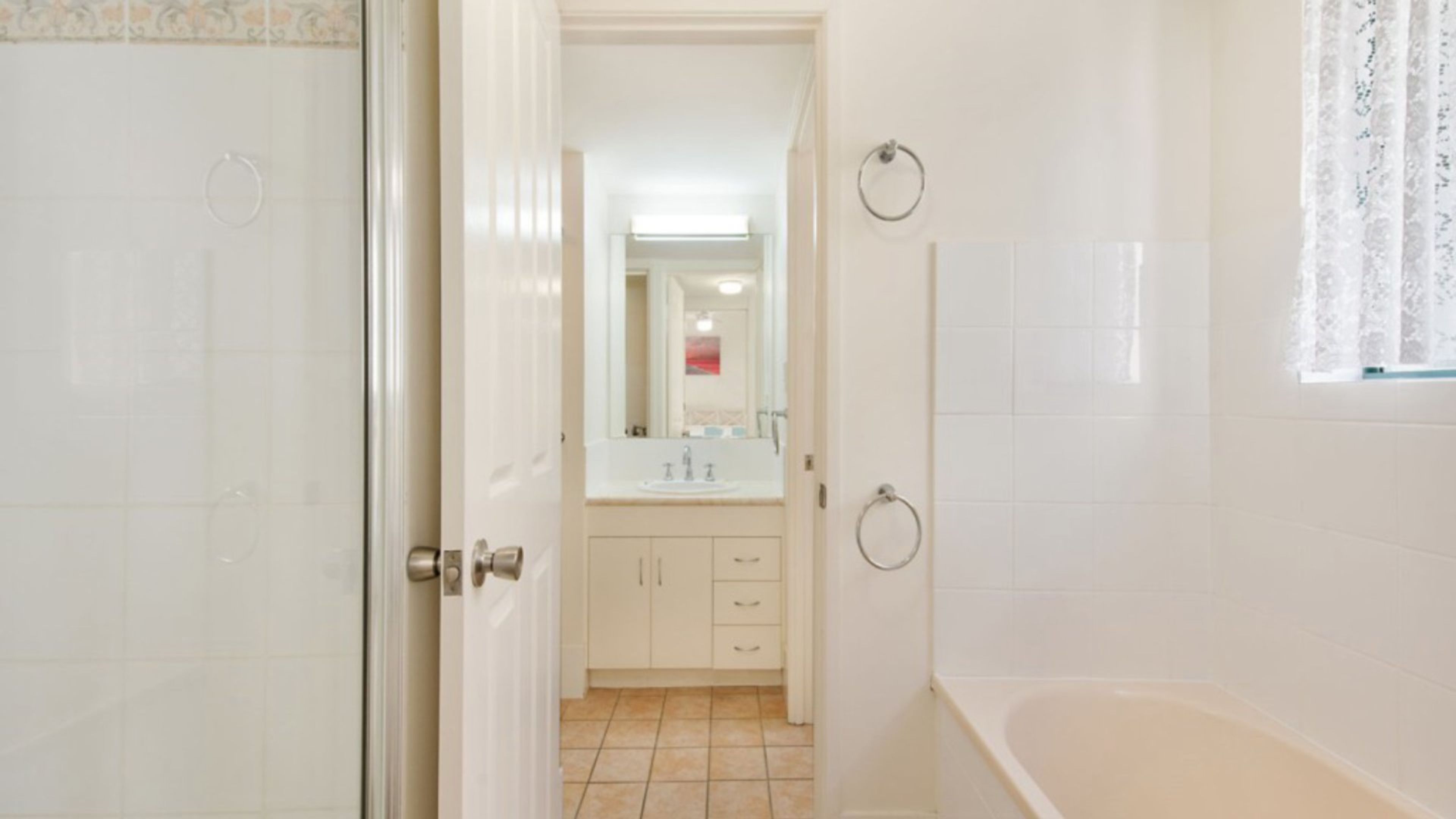 A bathroom with a bathtub, a sink, and a mirror.