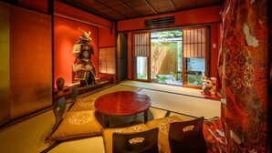 A traditional Japanese room with tatami flooring, a low table, and a shoji screen door leading to a garden. - Miyagawacho Samurai Machiya, Miyagawacho Samurai Machiya (京都市)