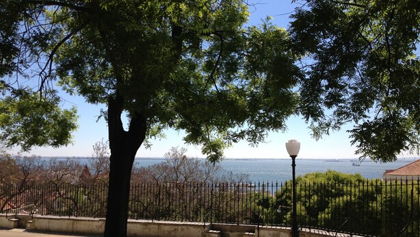 A park with a tree, a lamp post, and a view of the sea. - St Clara House-My Studio. Enjoy, visit or work @Graça (Lisboa)