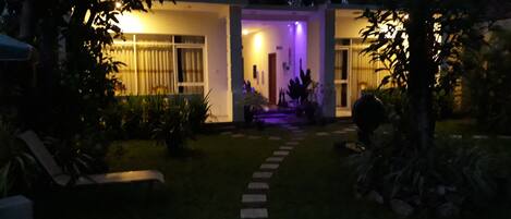 Une maison avec un chemin menant à une entrée éclairée.