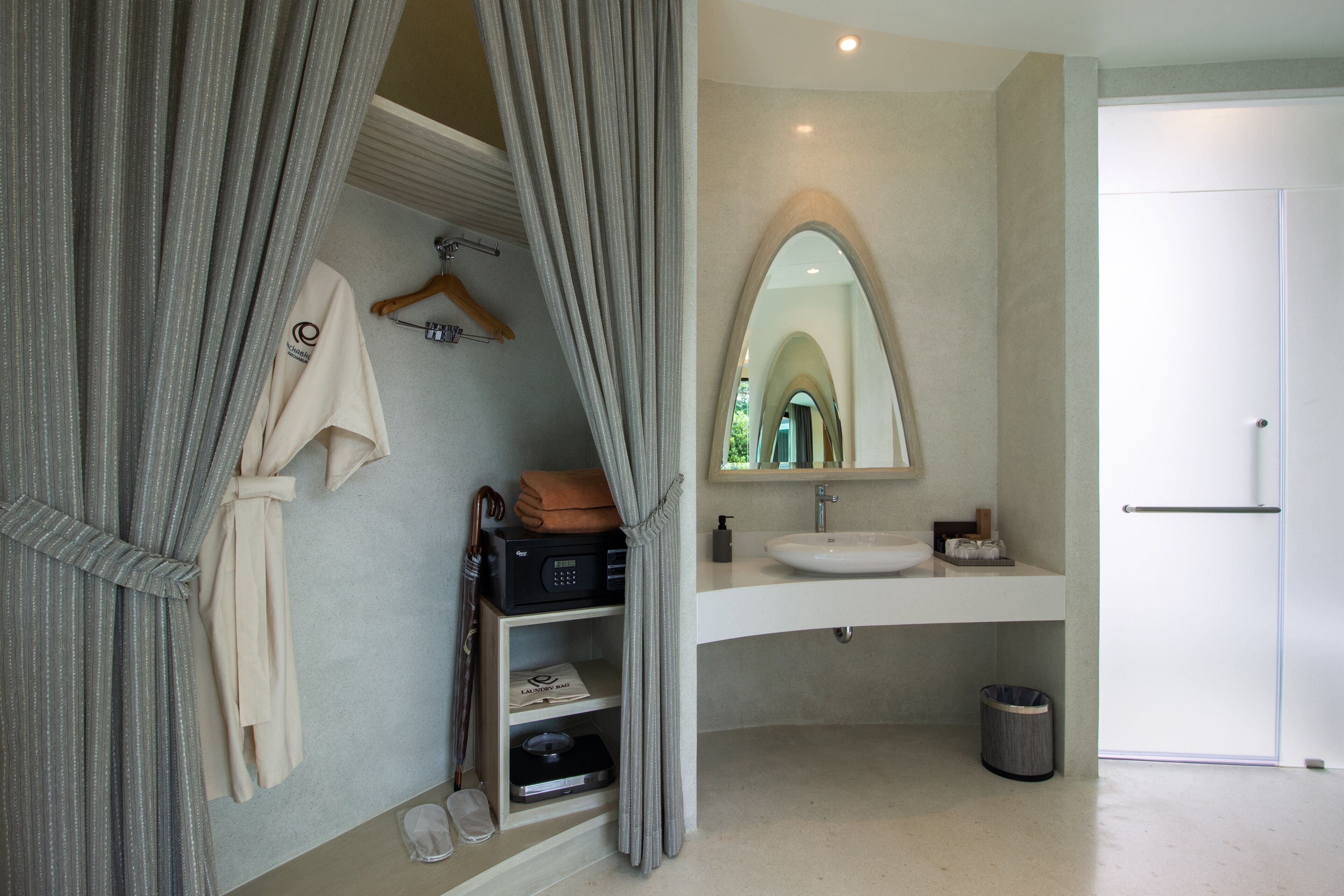 Un baño moderno con tocador, espejo y zona de ducha.