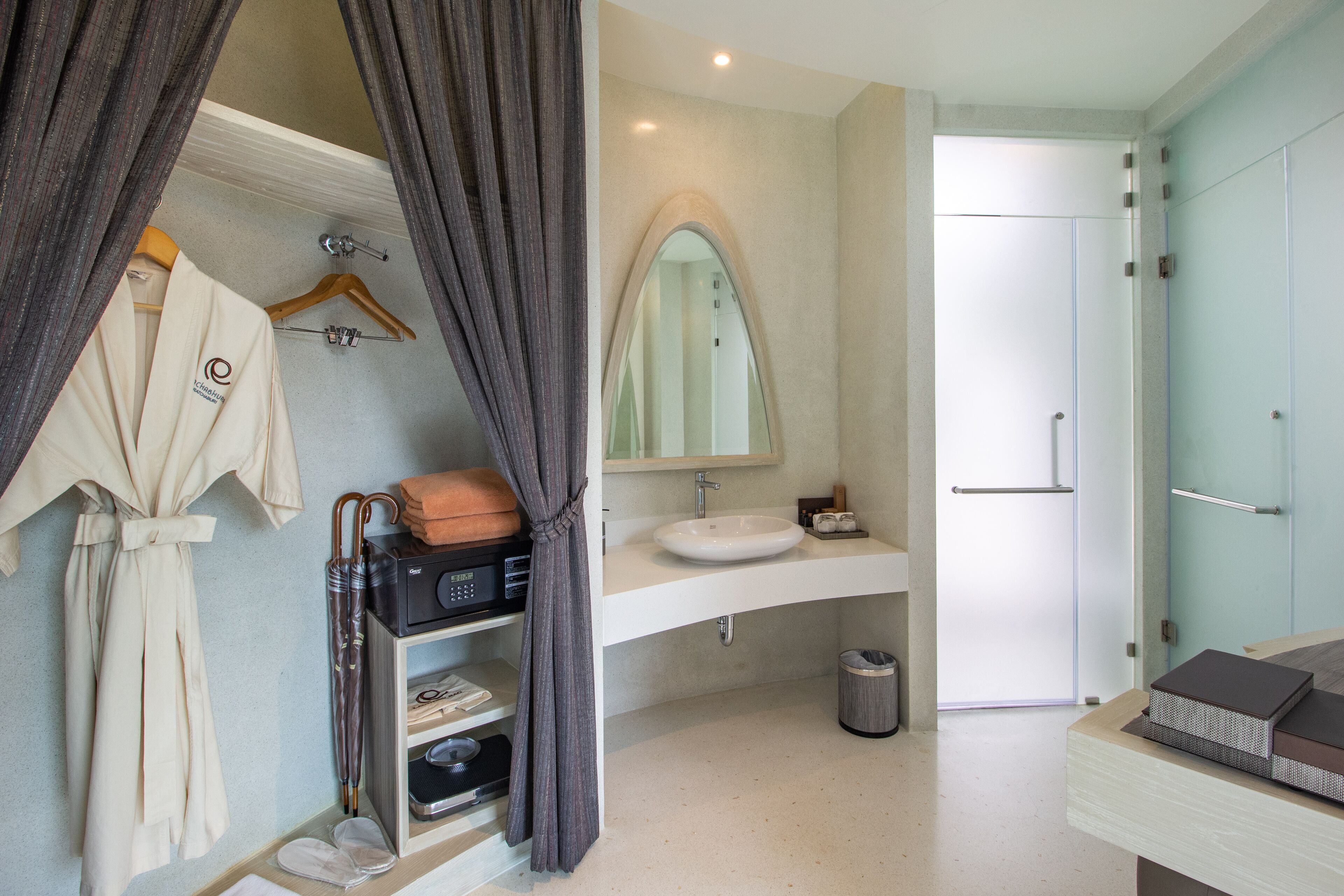 A modern bathroom with a vanity, mirror, and a shower area.