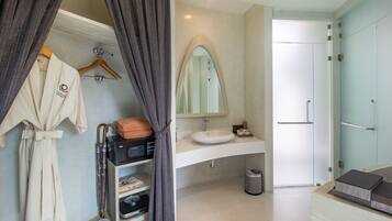 A modern bathroom with a vanity, mirror, and a shower area.