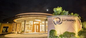 A hotel entrance with a circular design, a prominent sign, and a well-lit facade.