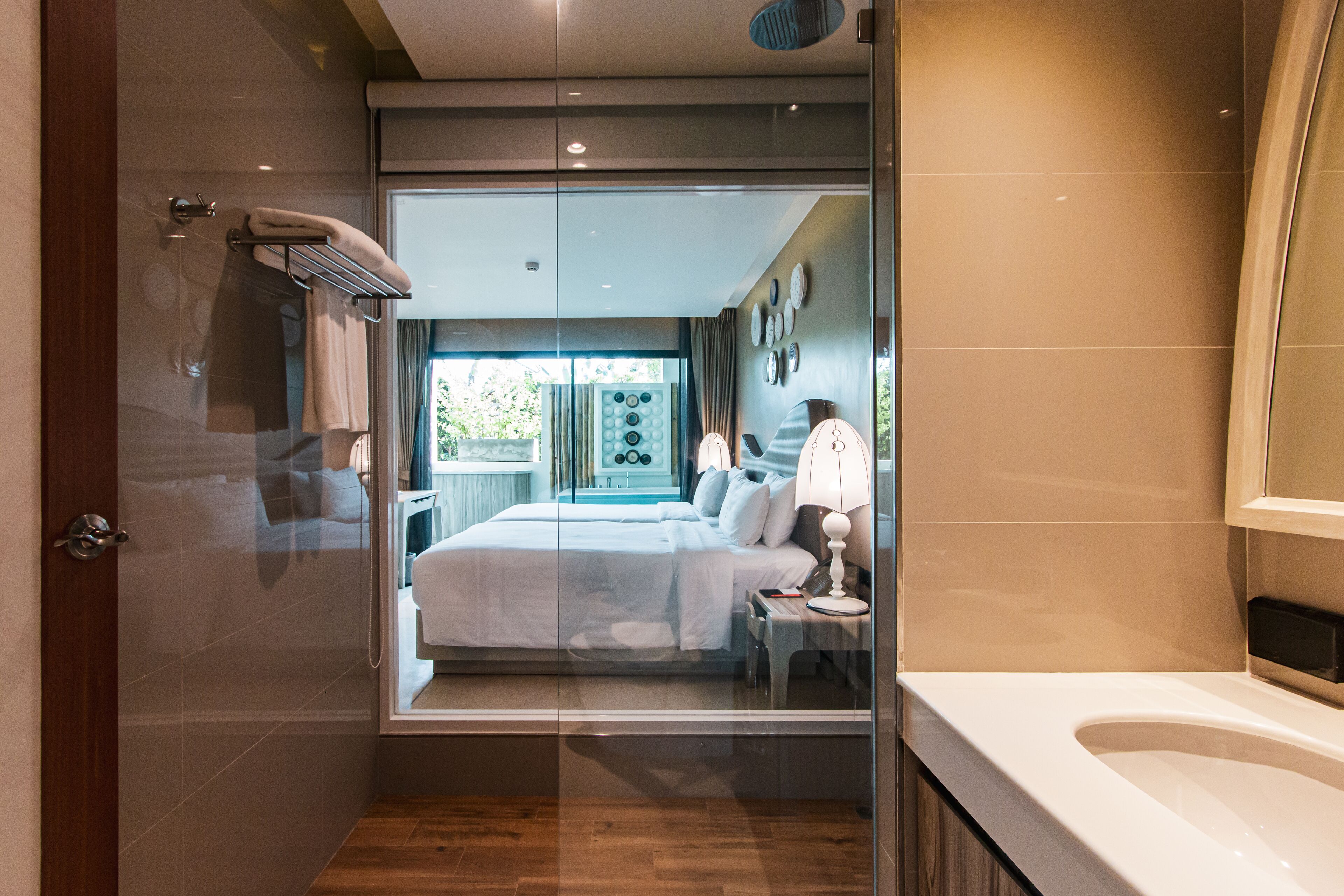 A modern bathroom with a glass shower enclosure, a bathtub, and a large mirror.