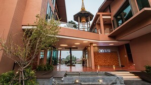 Un edificio moderno con una torre de campanas destacada, una cafetería y un bar.