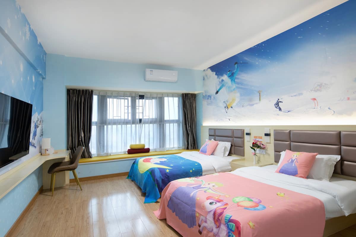 A hotel room with two beds, a desk, a chair, a TV, and a large window with curtains.