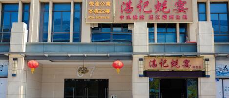 Un edificio con un letrero que indica un restaurante llamado "Honghe Wumiao" en la planta baja.
