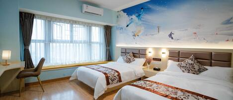 A hotel room with two beds, a desk, a chair, a large window with curtains, and a mural of a skier on the wall.
