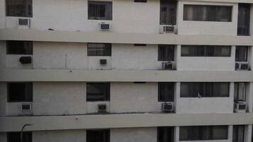 A multi-story hotel building with balconies and air conditioning units.