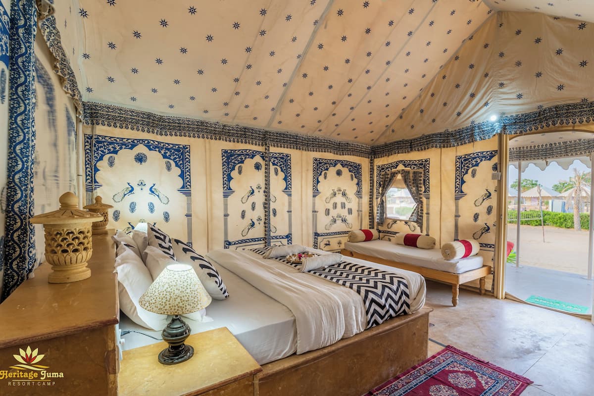 A traditional room with a bed, bedside table, lamp, and decorative pillows.